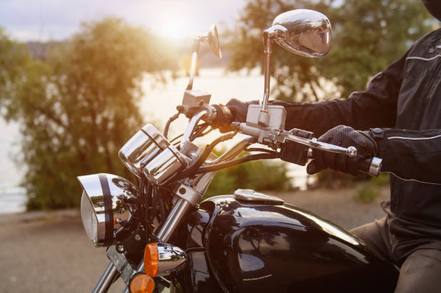 Motorcycle being riden with lake in background