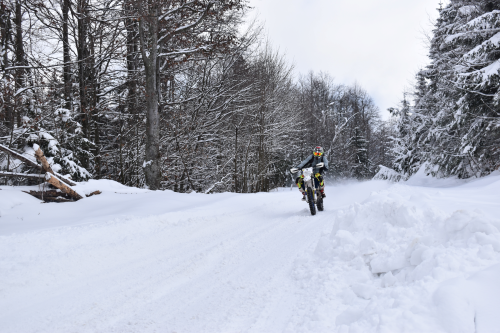 a man riding a snowboard down a snow covered slope